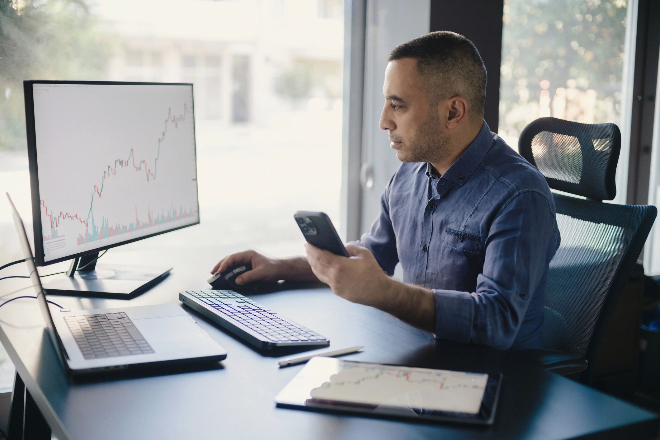 Trader working at computer with market charts
